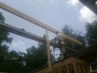 Carpenter setting a ridge beam over a new addition frame — Ice Dam Removal by Roofing Brothers in Red Wing