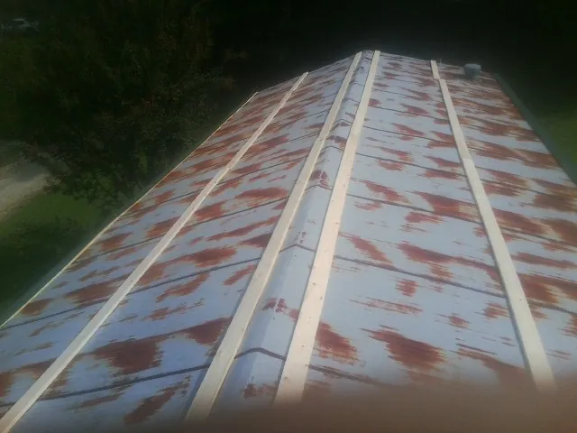 Rusted metal roof panels with new wood purlins before replacement — Storm Damage Roof Repair in Red Wing by Roofing Brothers